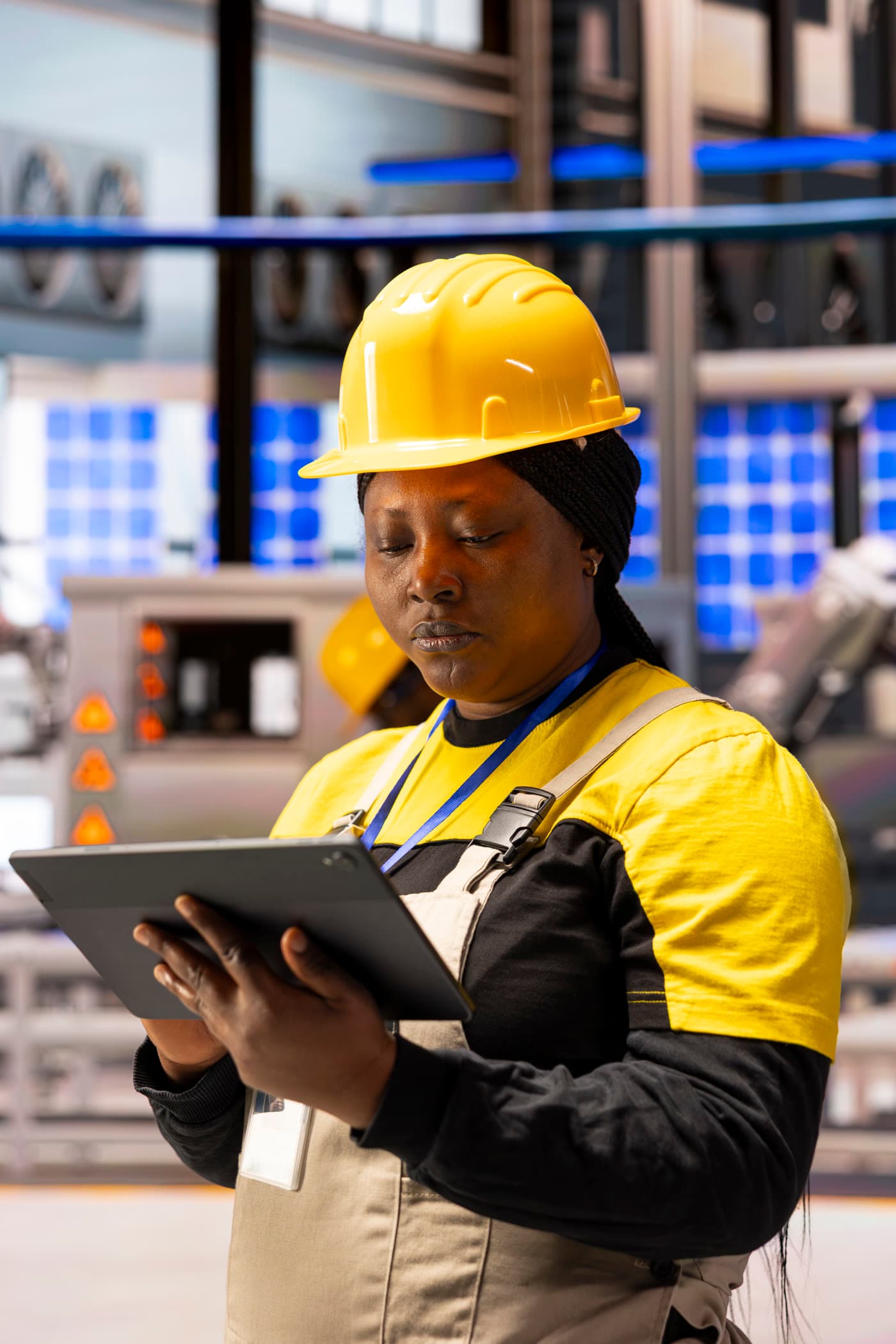 Engineer in a hard hat reviewing a tablet in a plant