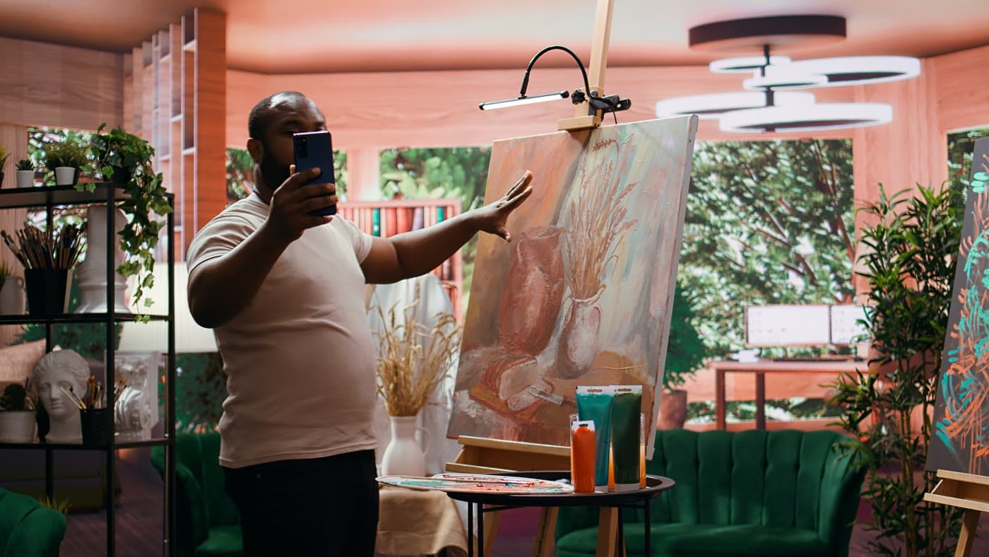 Man photographing his painting in a studio