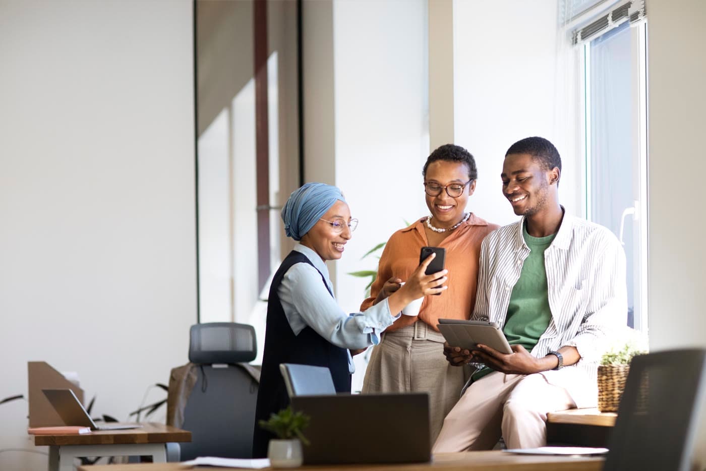 Colleagues gathered around a phone in an office